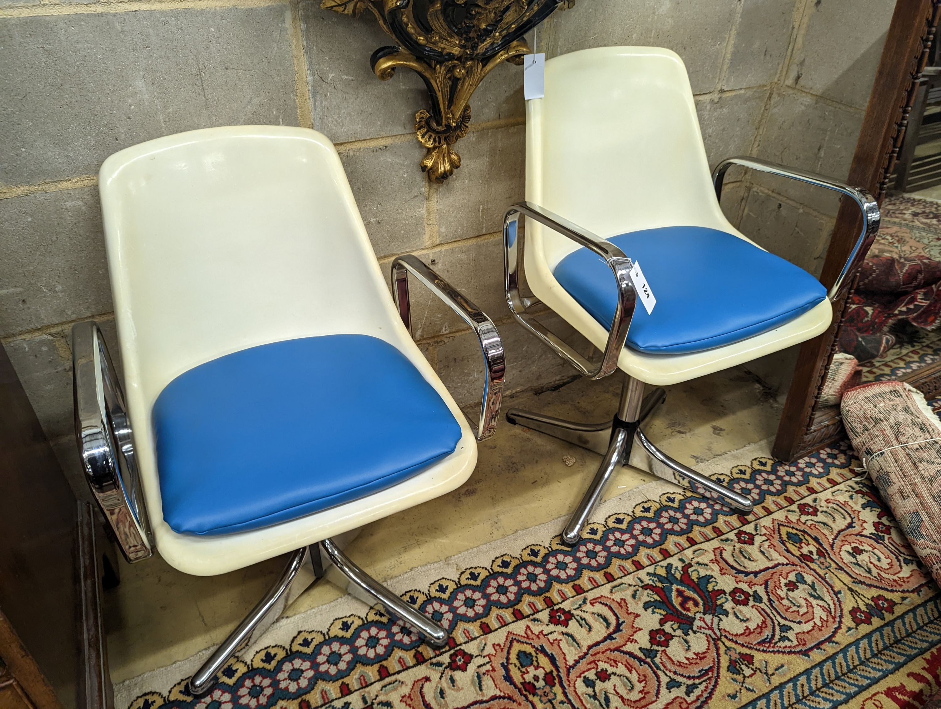 A pair of mid century Tulip style swivel chairs.